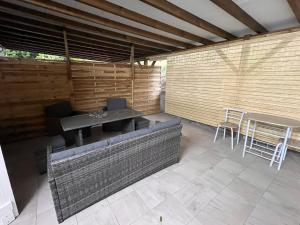 um pátio com um banco, uma mesa e cadeiras em Studio Roselande em Baillif