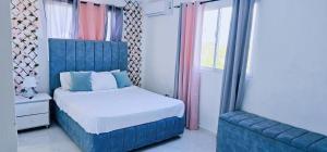 1 dormitorio con 1 cama azul y 1 silla azul en Casa familiar, en San Pedro de Macorís