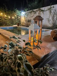 een lantaarn naast een zwembad in de nacht bij La Chiquitita in Villa Dolores