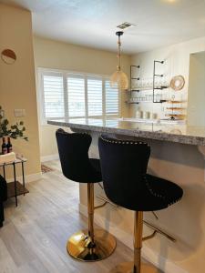 a kitchen with two black bar stools and a counter at Fragrant Finnish Sauna & Cozy Pool with French 3br in Las Vegas