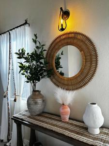 a mirror on a table with vases and a plant at Fragrant Finnish Sauna & Cozy Pool with French 3br in Las Vegas