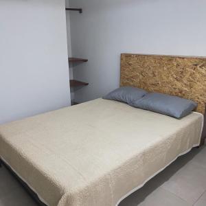 a bed with a blue pillow on top of it at Hospedaje Villa Justina in Santa Eulalia