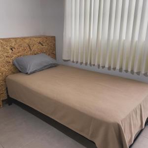 un letto in una camera con finestra e persiane di Hospedaje Villa Justina a Santa Eulalia