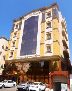 un edificio con coches estacionados frente a él en Hayat Al Rose Hotel Appartment, en Yeda