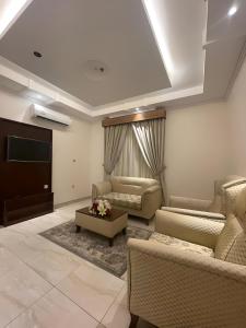 a living room with two couches and a tv at Hayat Al Rose Hotel Appartment in Jeddah