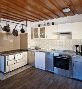 a large kitchen with stainless steel appliances and wooden floors at Almhof Grub in Wagrain