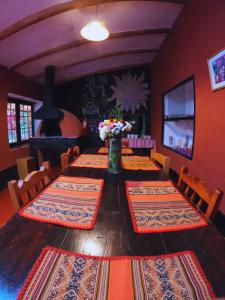 a dining room with a wooden table with a vase of flowers at B&B Sun Gate in Ollantaytambo