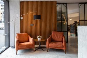 two orange chairs and a table in a lobby at Avenue Hotel Tbilisi in Tbilisi City