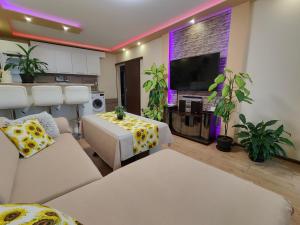 a living room with white furniture and a flat screen tv at Newly renovated 2 bedroom apartment in Sofia in Sofia