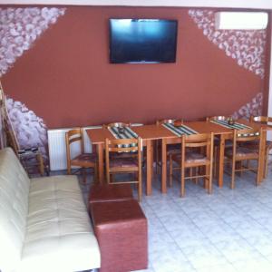 Hotel Loga في Tycherón: غرفة طعام مع طاولات وكراسي وتلفزيون على الحائط