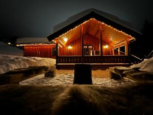 トリシルにあるTrysil Moderna Lodgeの雪に灯るログキャビン