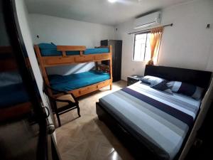 a bedroom with two bunk beds and a chair at APARTAMENTOS LIZ MARIA in Coveñas