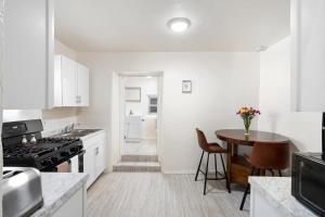 a kitchen with white cabinets and a wooden table at Studio Casita-15 min walk to Downtown Plaza in Santa Fe