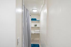 a bathroom with white walls and a hallway with towels at Studio Casita-15 min walk to Downtown Plaza in Santa Fe