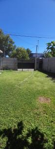une cour avec une clôture et un champ d'herbe dans l'établissement CASA TOBIAS, à Tandil