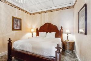 a bedroom with a large bed with white sheets at Maison Pierre Lafitte in New Orleans