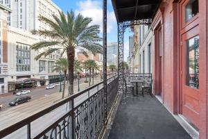 balkon budynku z palmami i ulicą w obiekcie Maison Pierre Lafitte w Nowym Orleanie