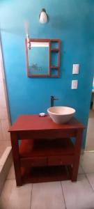 La salle de bains est pourvue d'un lavabo et d'un miroir sur un mur bleu. dans l'établissement CASA TOBIAS, à Tandil