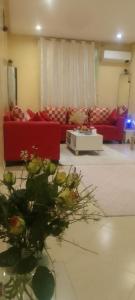 - un salon avec des canapés rouges et des fleurs à l'étage dans l'établissement Angel Appartement, à Marrakech