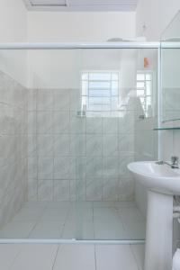 Baño blanco con lavabo y espejo en Sobrado 2 dormitórios no Tatuapé, en São Paulo