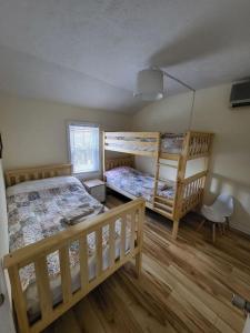 a bedroom with two bunk beds and a chair at Entire cottage, Firepit, BBQ, in & out pool access in Long Pond