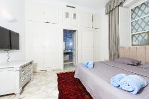 Un dormitorio con una cama con toallas azules. en Arabesque House en La Marsa