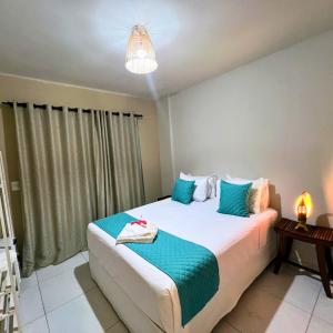 a bedroom with a large bed with blue pillows at Pousada Villa Bougainville Maragogi in Maragogi