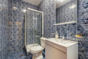 Baño de azulejos azules con aseo y lavamanos en Palma Apartments, en Herceg-Novi