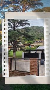 una imagen de una cerca con un árbol en el fondo en Casa Villa Carlos Paz en Villa Carlos Paz