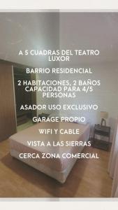Un dormitorio con una cama con palabras blancas. en Casa Villa Carlos Paz en Villa Carlos Paz