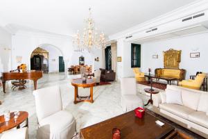 a living room with white furniture and a chandelier at Arabesque House in La Marsa