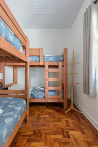 sypialnia z 2 łóżkami piętrowymi i drewnianą podłogą w obiekcie Sobrado 2 dormitórios no Tatuapé w São Paulo