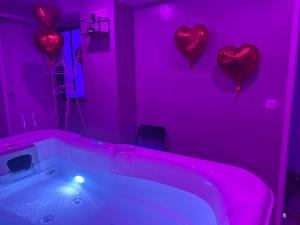 a pink bathroom with hearts on the wall and a tub at Jacuzzi privé arrivée autonome in Conflans-Sainte-Honorine