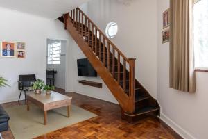 a living room with a staircase and a tv at Sobrado 2 dormitórios no Tatuapé in São Paulo