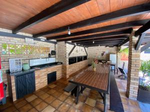 una cocina al aire libre con mesa y barra en Chalés do Holandês Eco Pousada, en Bombinhas