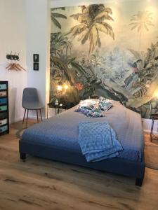 Un dormitorio con una cama azul con una pintura en la pared en Ks Kotten Bed and Breakfast, en Rees