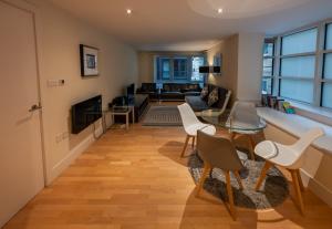 een woonkamer met een tafel en stoelen bij Modern Apartment in Central London By River Thames in Londen