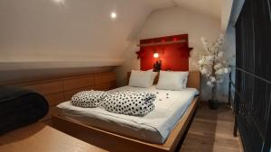 WELLNESS LOFT with Sauna, Jacuzzi, Roof Terrace & Amazing View في أنتويرب: غرفة نوم مع سرير مع وسائد سوداء وبيضاء