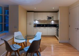 a kitchen with a glass table and chairs at Modern Apartment in Central London By River Thames in London