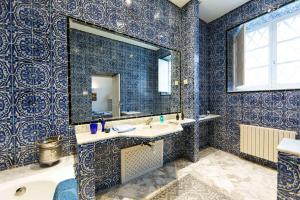 a blue bathroom with a sink and a mirror at Arabesque House in La Marsa