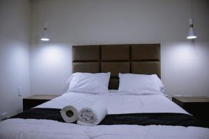 Una cama con dos rollos de papel higiénico. en PRANA HOTEL LOUNGUE BAR, en Huancayo