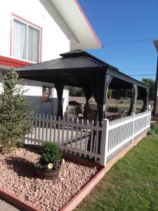 a gazebo with a black covering on a house at Travel Inn Motel in Canon City