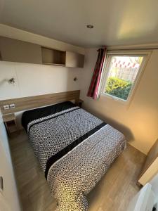 a bed in a small room with a window at mobilhome 6/8 pers. camping siblu les charmettes in Les Mathes