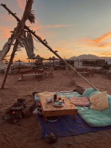 a group of tents on the beach with a table at Black Prince camp in Dahab