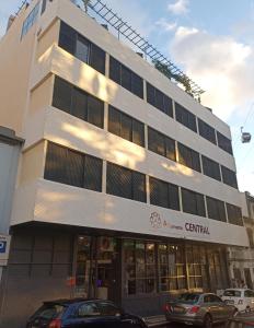 un bâtiment avec des voitures garées devant lui dans l'établissement Alojamento Central - Funchal, à Funchal