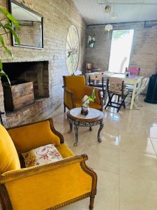 a living room with couches and a table and a fireplace at Chacra La Escondida in Colonia del Sacramento