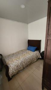 a bedroom with a bed with a blue pillow on it at Luxury 3 Bedroom Apartment in Puerto Limón