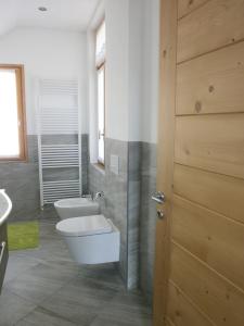 ein Bad mit einem WC, einem Waschbecken und einer Tür in der Unterkunft Appartamenti Via Monte Braulio 19 in Bormio