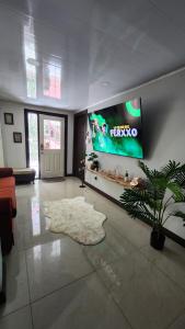 ein Wohnzimmer mit einem großen TV an der Wand in der Unterkunft Luxury 3 Bedroom Apartment in Puerto Limón