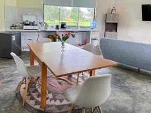 comedor con mesa y sillas y cocina en Room in Bungalow - Grandfathers Farm - Disfruta de la naturaleza en un lindo flat, en Cajamarca